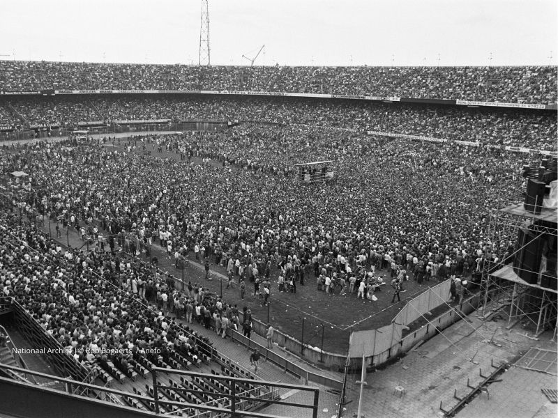 Een volle Kuip tijdens het Simon & Garfunkel‑concert op 12 juni 1982, gezien schuin achter het podium met zicht op het veld en de tribunes.